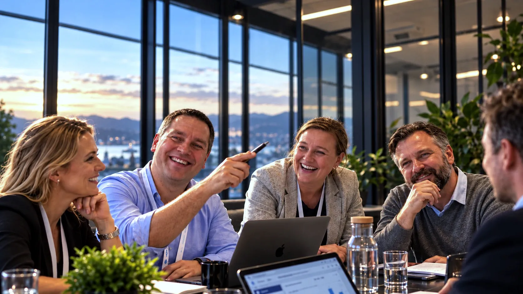 A smiling team around a meeting table, with a view of the city at sunset